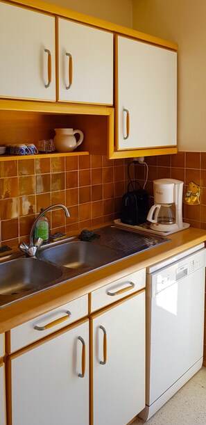 A kitchen with a sink, coffee maker, and a dishwasher. - Golfe Juan charmant appartement garage proche mer (Vallauris)