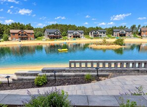 Vue sur un quartier résidentiel au bord d’un lac, avec de nombreuses maisons, un quai et un ciel dégagé.