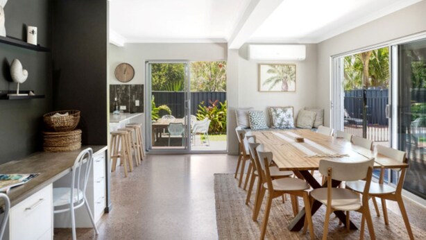 Una cucina moderna con zona pranzo, ampie finestre e vista sul giardino.