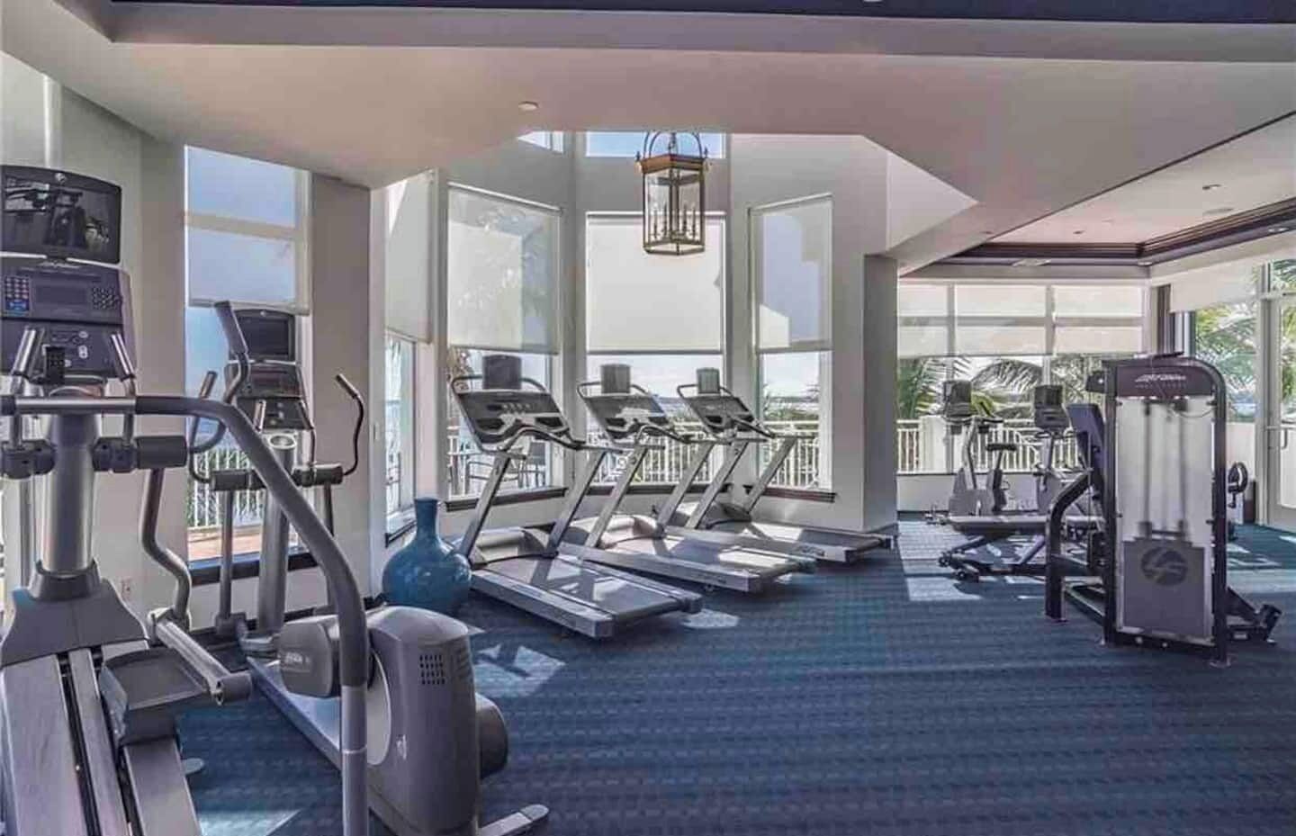 A gym with treadmills, elliptical machines, and weight equipment.