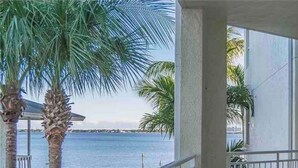 A balcony with a view of the sea and palm trees. - Waterfront condo in beautiful Stuart, Close to Jensen and Stuart beaches. (Stuart)