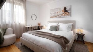 Ein Schlafzimmer mit einem Bett, einem Schreibtisch, einem Stuhl, einer Lampe und einem Gemälde an der Wand.