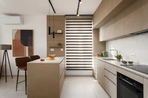 A modern kitchen with a central island, built-in appliances, and a minimalist design. - Premium apartment My Way with panoramic balcony (Labin)