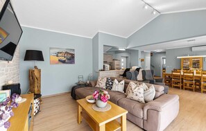 Ein modernes Wohnzimmer mit einer Couch, einem Couchtisch, einem Fernseher und Kunstwerken.