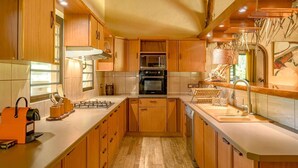 A kitchen with wooden cabinets, a stove, oven, and a sink.