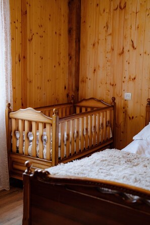 Un berceau en bois dans une pièce aux murs en bois.