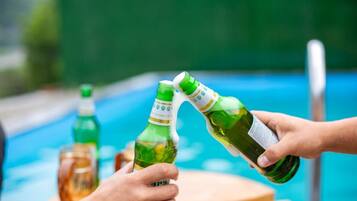 Een zwembadlandschap, waarbij iemand een drankje inschenkt uit een groene fles.