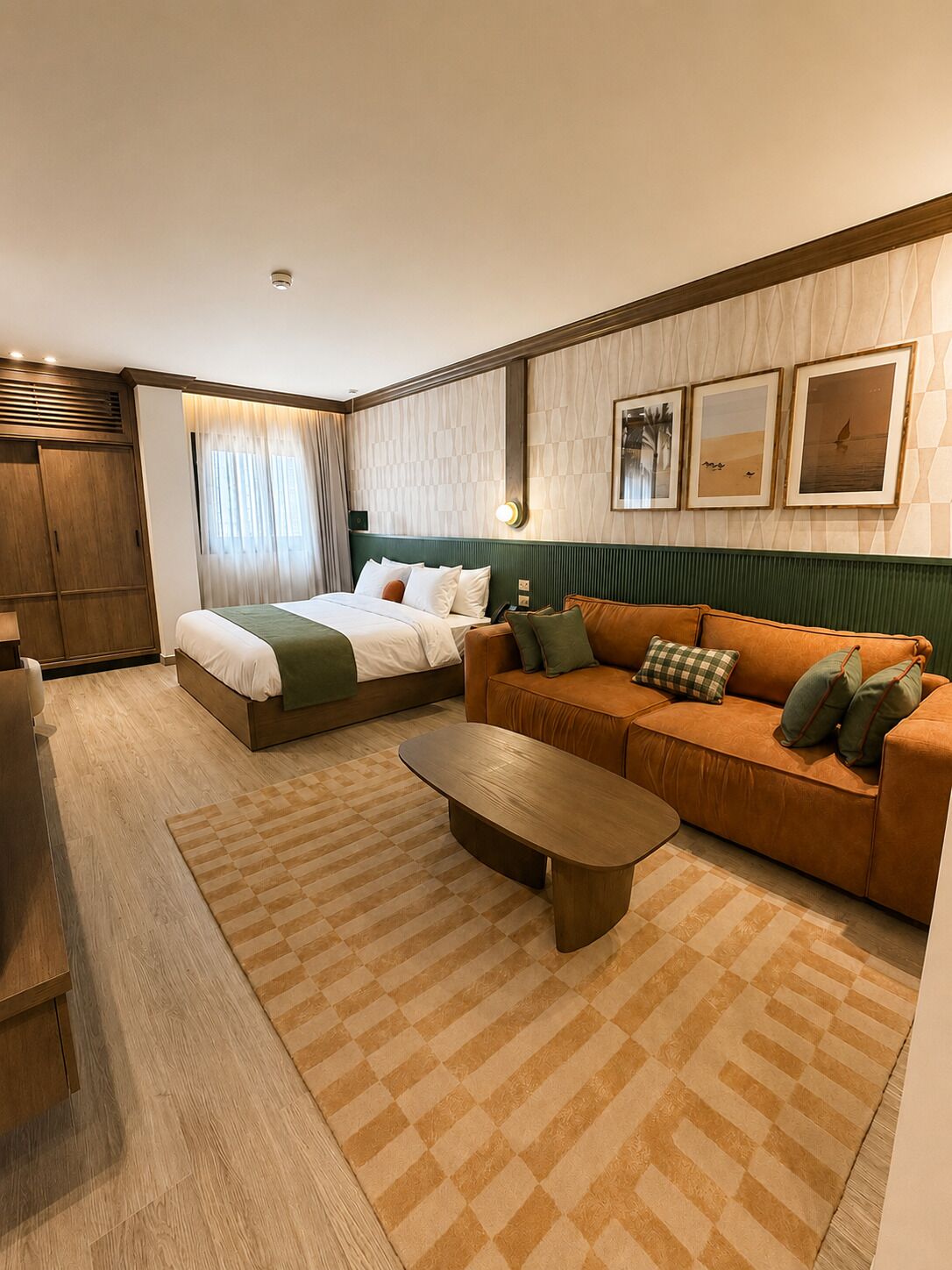 A hotel room with a bed, a sofa, a coffee table, and a wardrobe.