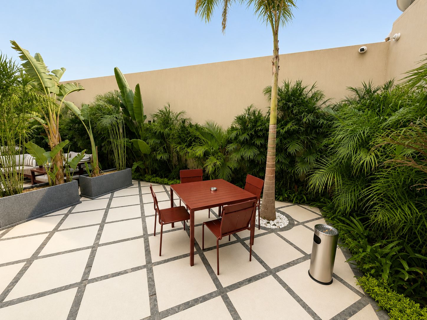 An outdoor patio with a table and chairs, surrounded by lush greenery and a tiled floor.