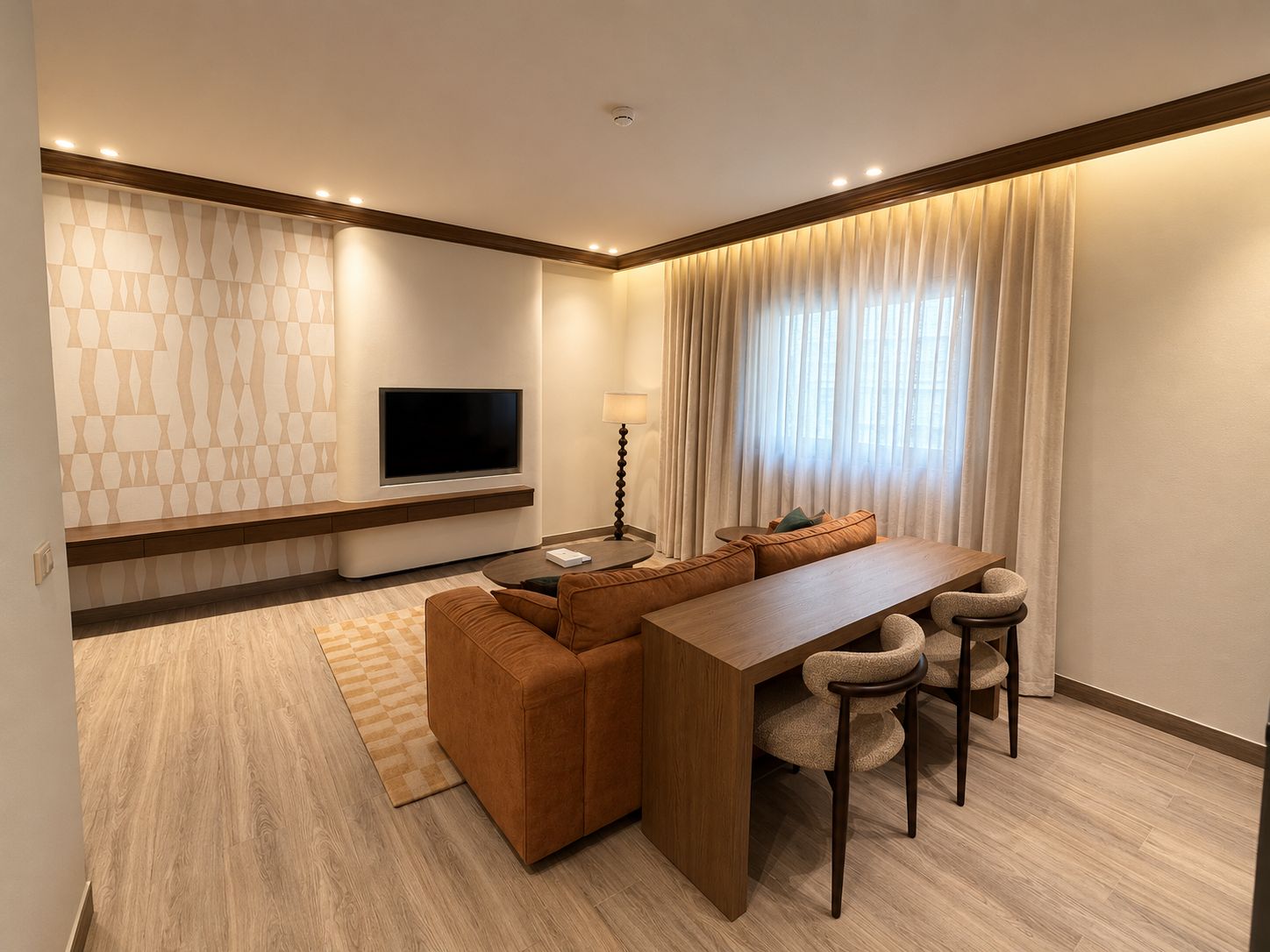 A modern hotel room with a flat-screen TV, a sofa, a dining table with chairs, and a large window with curtains.
