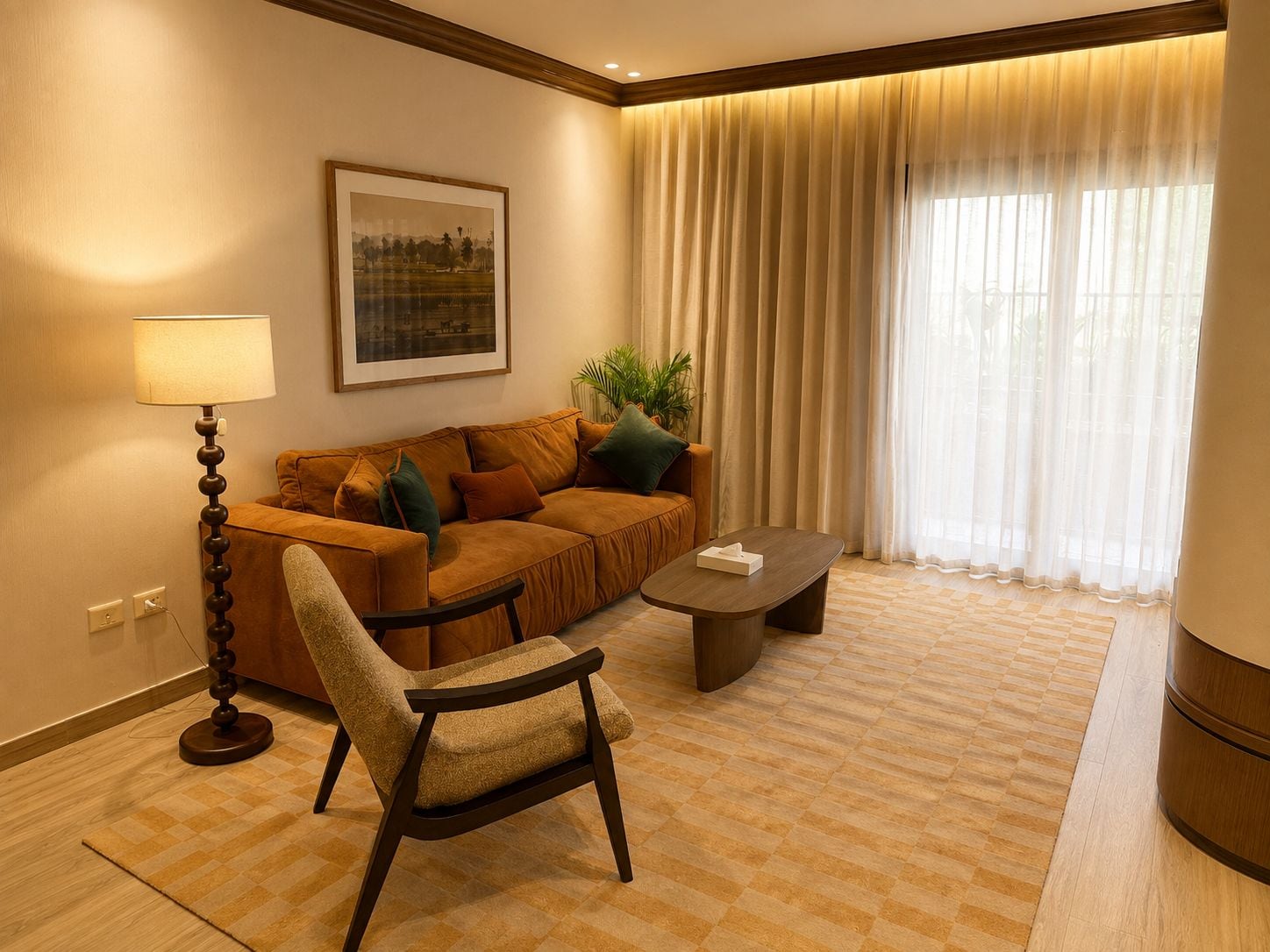 A hotel room with a sofa, armchair, lamp, and a framed picture on the wall.