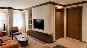 A modern living room with a flat-screen TV, a sofa, a coffee table, and a TV stand.