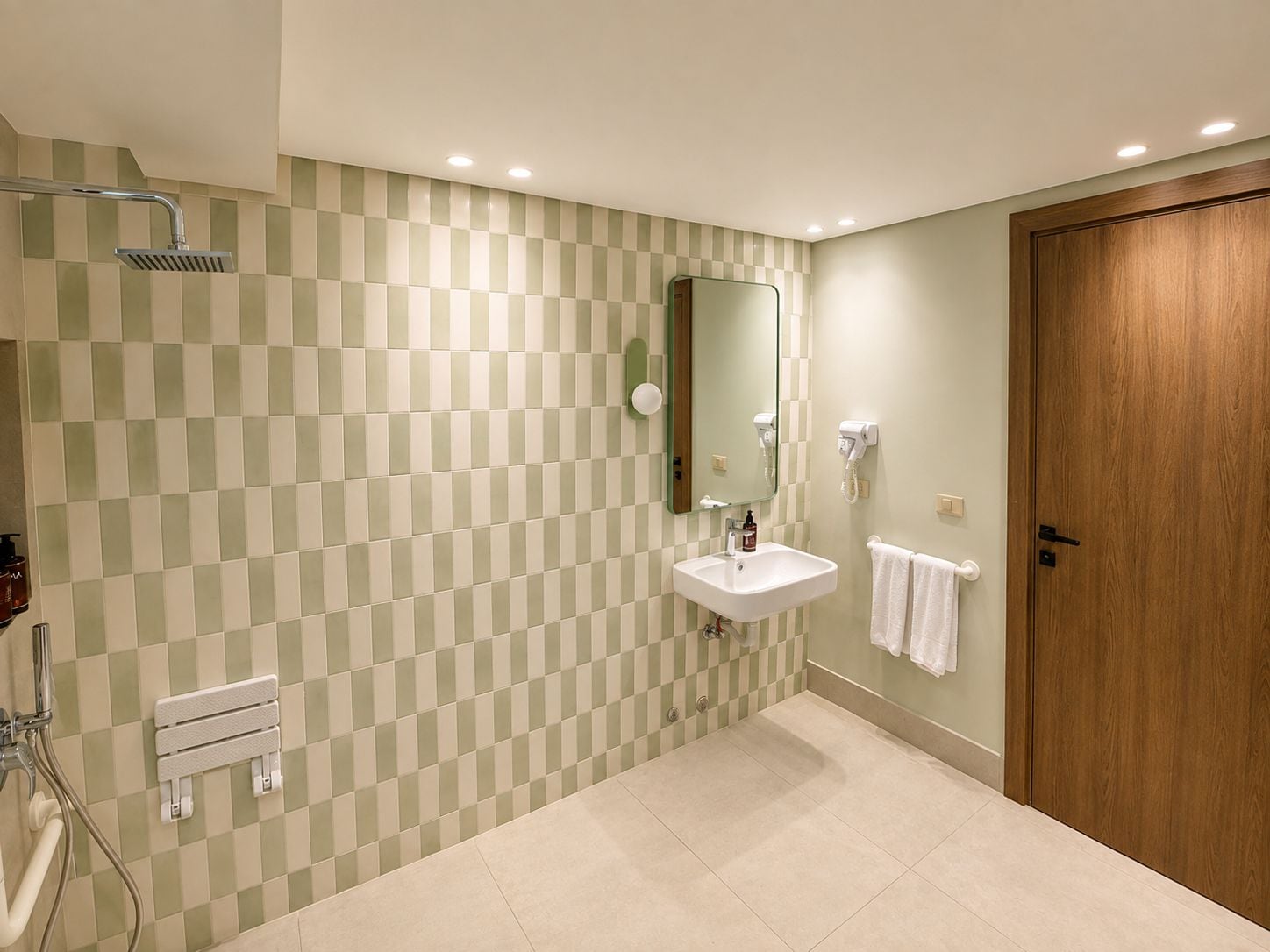 Une salle de bain avec un mur orné d’un motif à carreaux, un lavabo, un miroir, un porte-serviettes et une porte en bois.