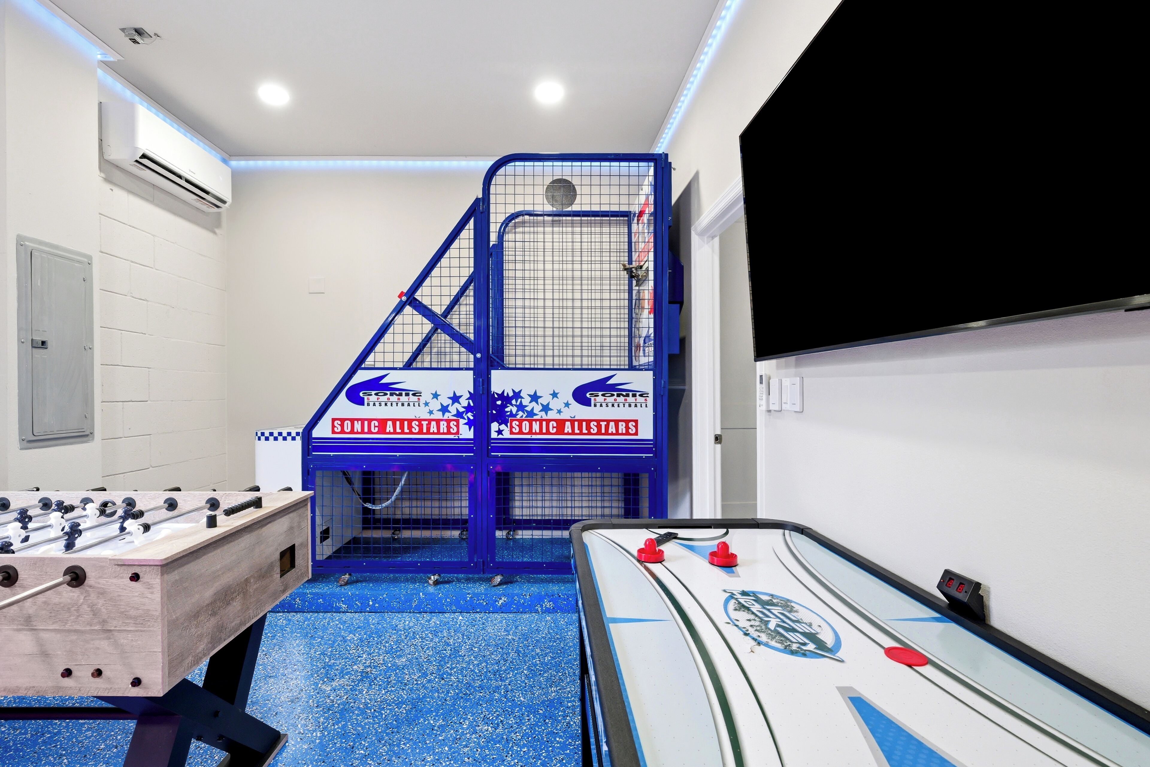 Una habitación con mesa de fútbol, mesa de billar y una estructura de juego azul que dice 'Sonic Allstars'.