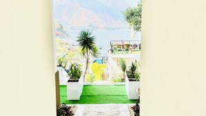 A pathway leading to a balcony with a view of a mountain and a body of water. - Luxury Atitlan Apartamentos  (San Pedro La Laguna)