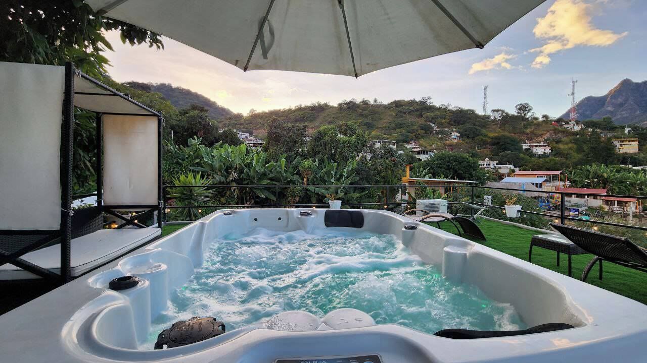 A hot tub with a view of a mountainous landscape.