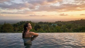 A person in a pool with a view of a landscape. - AURALTA RIO CELESTE I Elohi Collection (Katira)