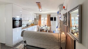 A compact room with a kitchenette, a bed, a dining area, and a large mirror. - Stunning apartment in Omisalj with WiFi (Omisalj)