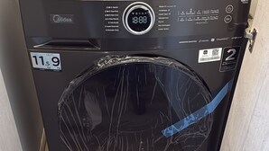 A black Midea washing machine with a digital display, a weight indicator, and a power button. - Valpo Coast Suites · Modern Apartment + Parking + Rooftop (Valparaíso)