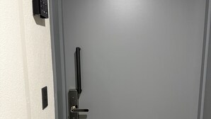 A closed door with a modern handle and a control panel on the wall. - Valpo Coast Suites · Modern Apartment + Parking + Rooftop (Valparaíso)