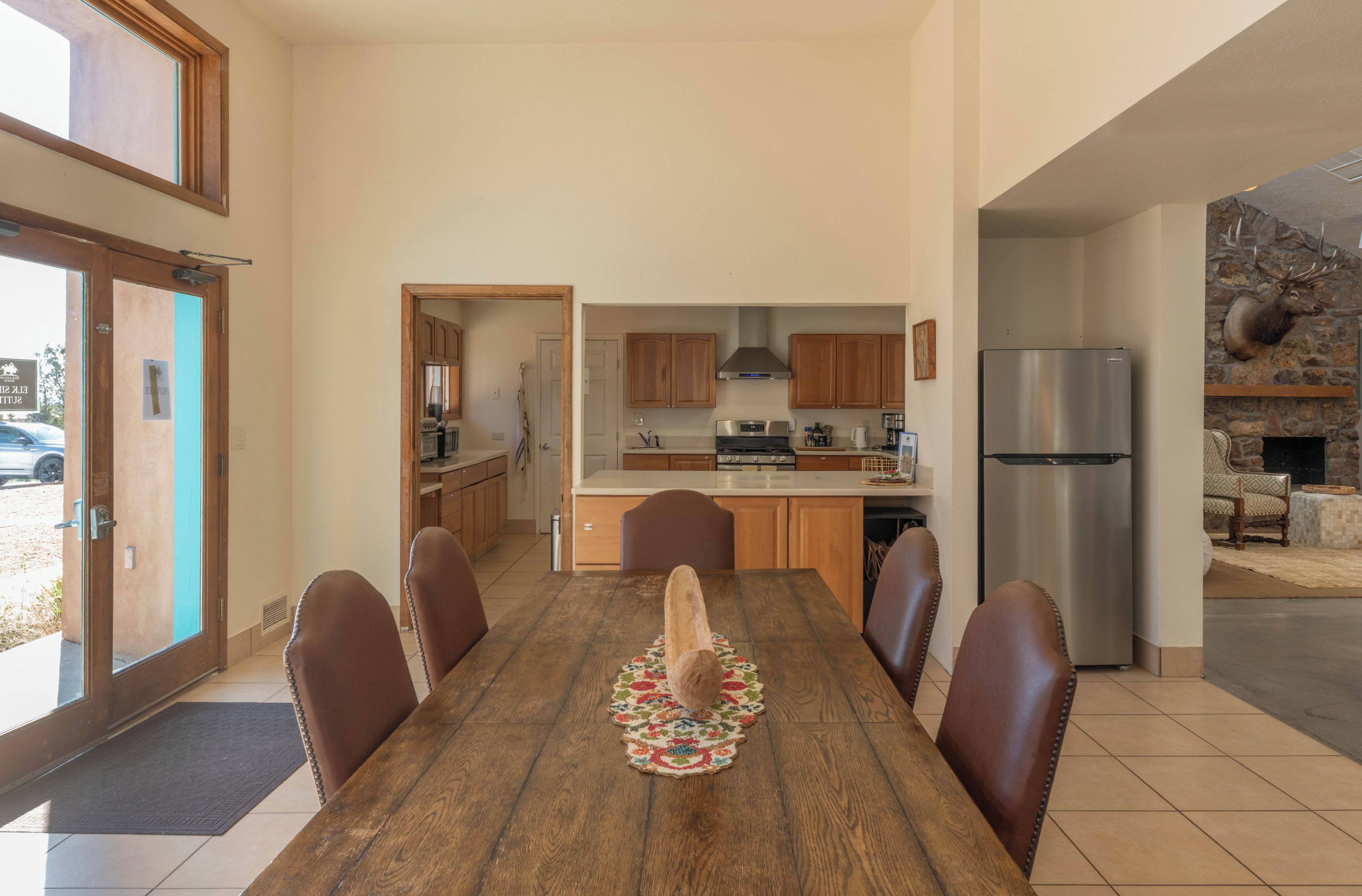 A dining area with a wooden table, six chairs, and a central rug.