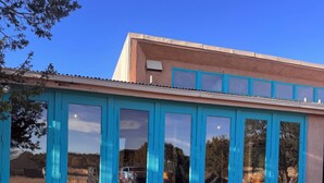 A building with a blue exterior and large windows.