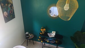 Ein Essbereich mit einem runden Tisch, gedeckt für ein Frühstück, einer türkisblauen Akzentwand, einer Pendelleuchte und einem gerahmten Kunstwerk an der Wand.