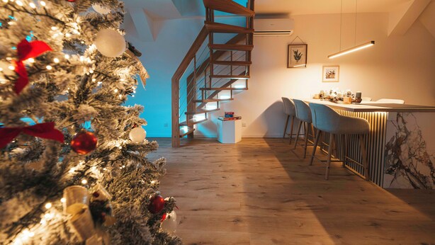 Ein modernes Interieur mit einer Holztreppe, einer Bar und einem Weihnachtsbaum.