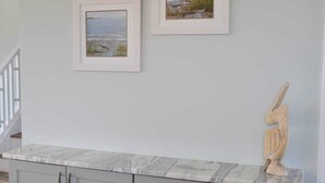 A kitchen with grey cabinets and a marble countertop. - Coastal Retreat Near Beaufort (Beaufort)