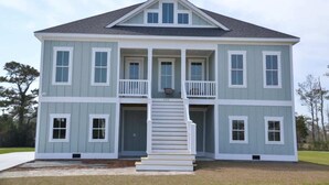 A two-story house with a front porch, a staircase, and a garage. - Coastal Retreat Near Beaufort (Beaufort)