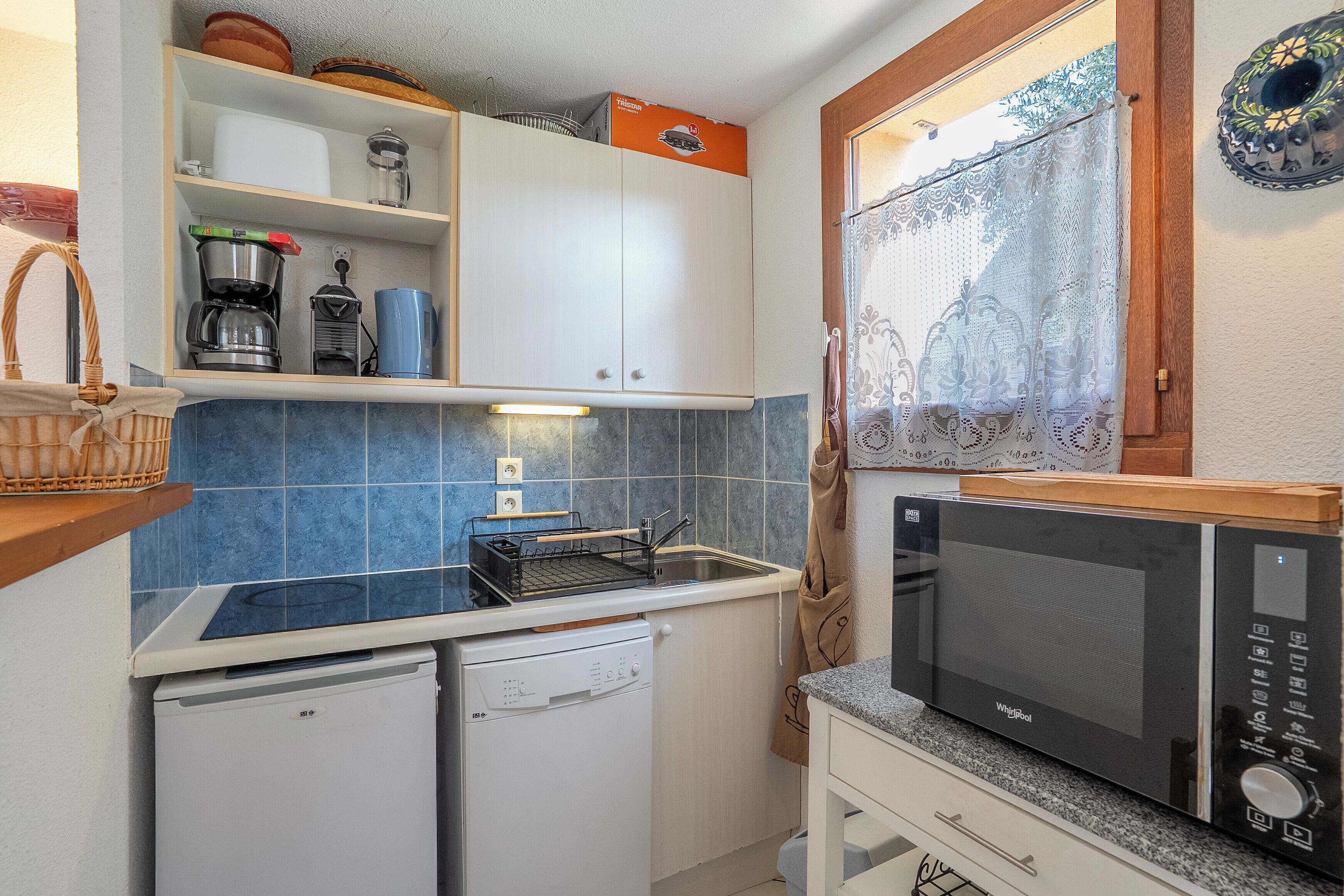 Een kleine keuken met een vaatwasser, een magnetron en een broodrooster.