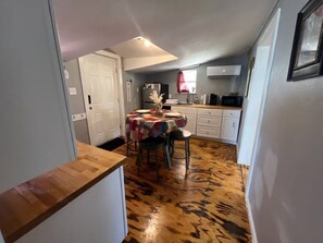 A compact kitchen with a dining table, chairs, a refrigerator, and a microwave. - Perfect for 2: Pet Friendly (San Angelo)