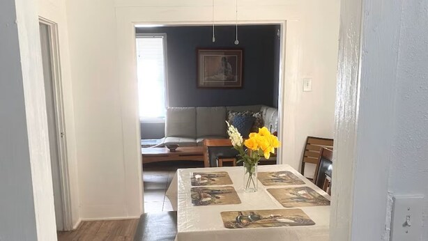 A dining area with a table set for two, a bench, and a vase with flowers. - Sleeps 4/ Fenced Yard/ Pet Friendly/ Near Downtown (San Angelo)