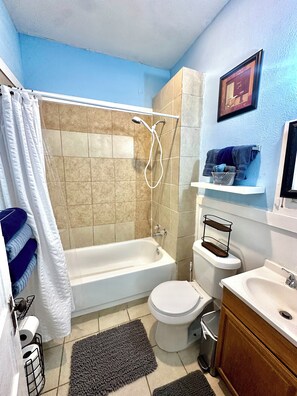 A bathroom with a bathtub, toilet, and sink. - Sleeps 4/ Fenced Yard/ Pet Friendly/ Near Downtown (San Angelo)