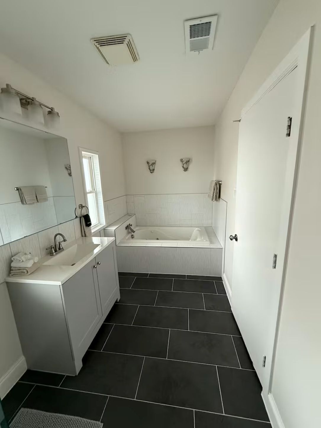 Une salle de bain moderne avec une baignoire, un lavabo et un miroir.