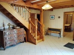 Eine Holztreppe mit einer Bank und einem Schmuckkästchen in einem Raum mit Fliesenboden.