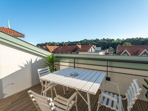 A rooftop terrace with a table and chairs, a potted plant, and a view of buildings with red roofs. - Bright apartment, parking - 6 guests in Arcachon (Arcachon)