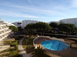 A residential building with a swimming pool, surrounded by greenery and other buildings. - Studio cabin with pool, close to beach and shops (La Grande-Motte)
