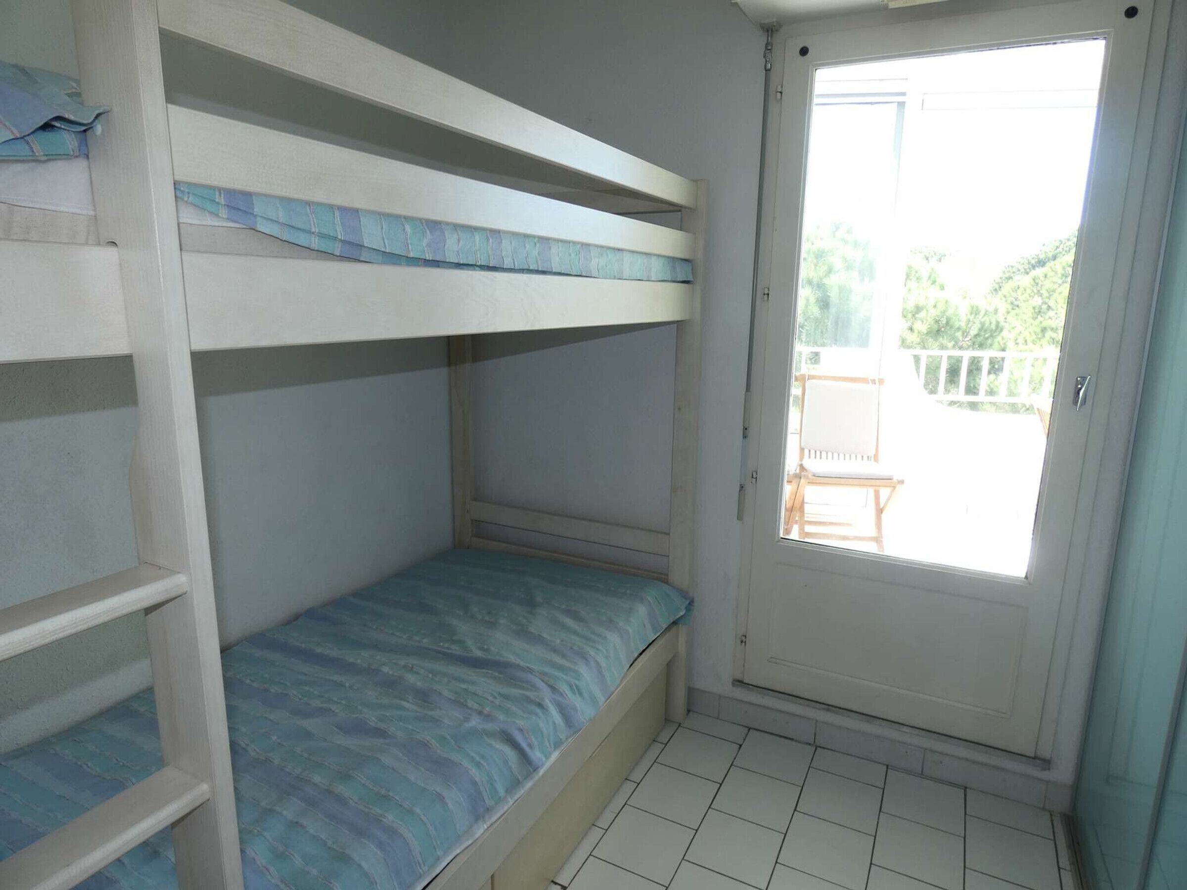 A bunk bed room with a door leading to an outdoor area.