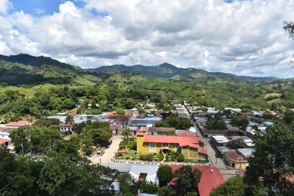 A town with buildings surrounded by green hills.