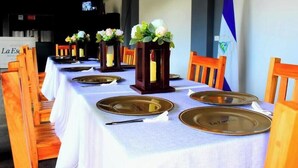 Una mesa de comedor dispuesta con platos, cubiertos y centros de mesa florales.