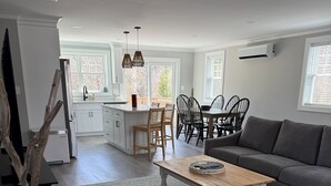 A modern living room with a grey sofa, a wooden coffee table, and a patterned rug. - New build. 3 bedroom Townhouse walking distance to York Beaches. (York)
