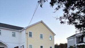 A two-story building with a garage, a driveway, and a parked vehicle. - New build. 3 bedroom Townhouse walking distance to York Beaches. (York)