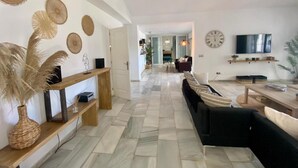 A spacious living area with a sofa, a TV, and decorative wall art. - Large villa Puerto Banús 10 bedrooms with pool and jacuzzi (Marbella)