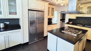 A modern kitchen with white cabinets, a stainless steel refrigerator, a gas stove, and a built-in oven. - Large villa Puerto Banús 10 bedrooms with pool and jacuzzi (Marbella)