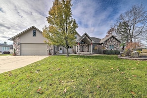 A two-story house with a stone facade, a garage, and a well-maintained lawn.