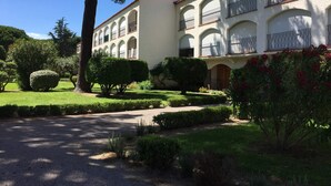 A building with a symmetrical facade, multiple balconies, and a well-maintained garden with hedges and trees. - Functional and bright studio, garden - 4 guests (Argelès-sur-Mer)