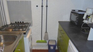 A compact kitchen with a gas stove, a microwave, and a coffee maker. - Functional and bright studio, garden - 4 guests (Argelès-sur-Mer)