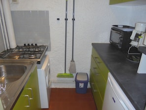 A compact kitchen with a gas stove, a microwave, and a coffee maker. - Functional and bright studio, garden - 4 guests (Argelès-sur-Mer)