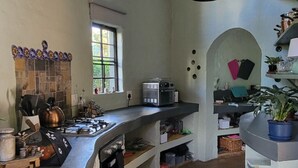 Une cuisine équipée d’une cuisinière à gaz, d’un four à micro-ondes et de divers ustensiles de cuisine.